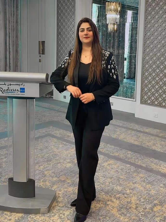 Hira Majeed beside a lectern in a Dubai conference hall
