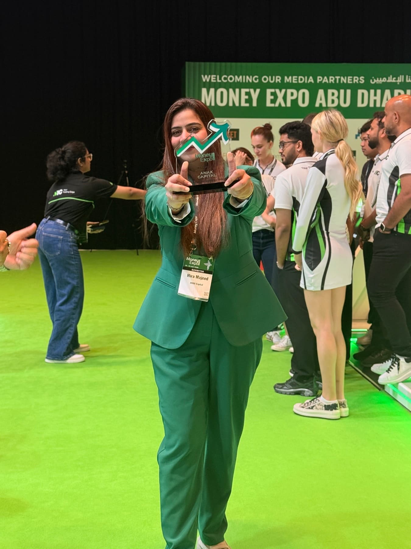 Hira Majeed holding an award on the exhibition floor at Money Expo Abu Dhabi